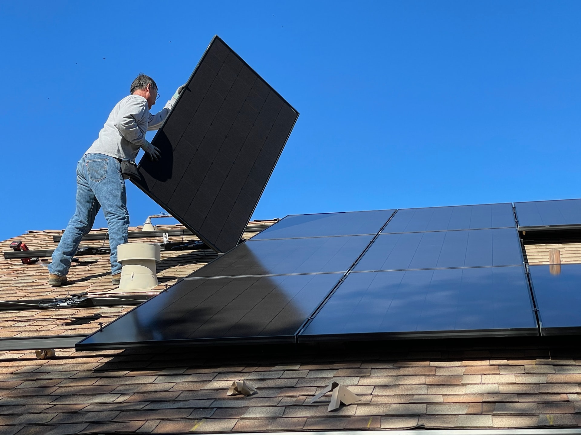 Man installing a solar panel on a roof